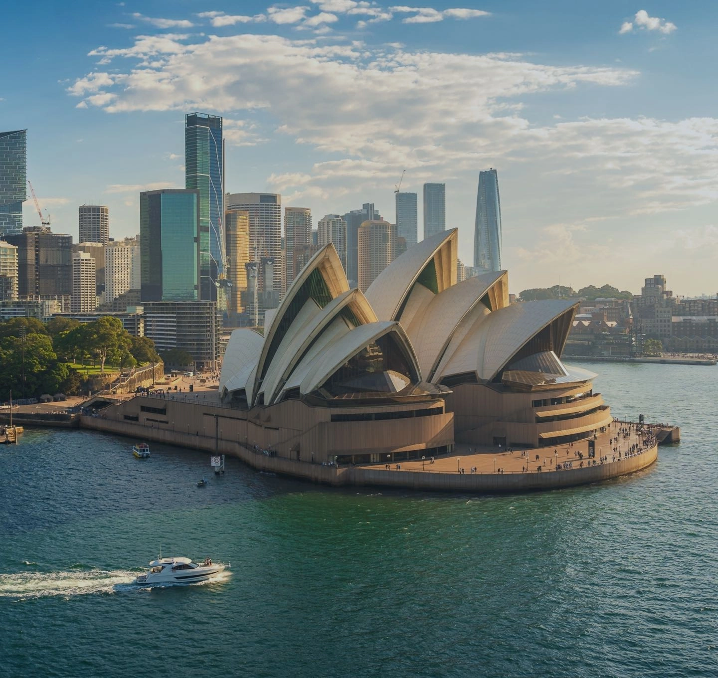 The Sydney Opera House and harbour bridge at dusk, with the city skyline behind.