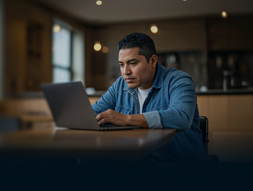 A yard manager reviewing ScrapIT on a laptop in a quiet open-plan office.